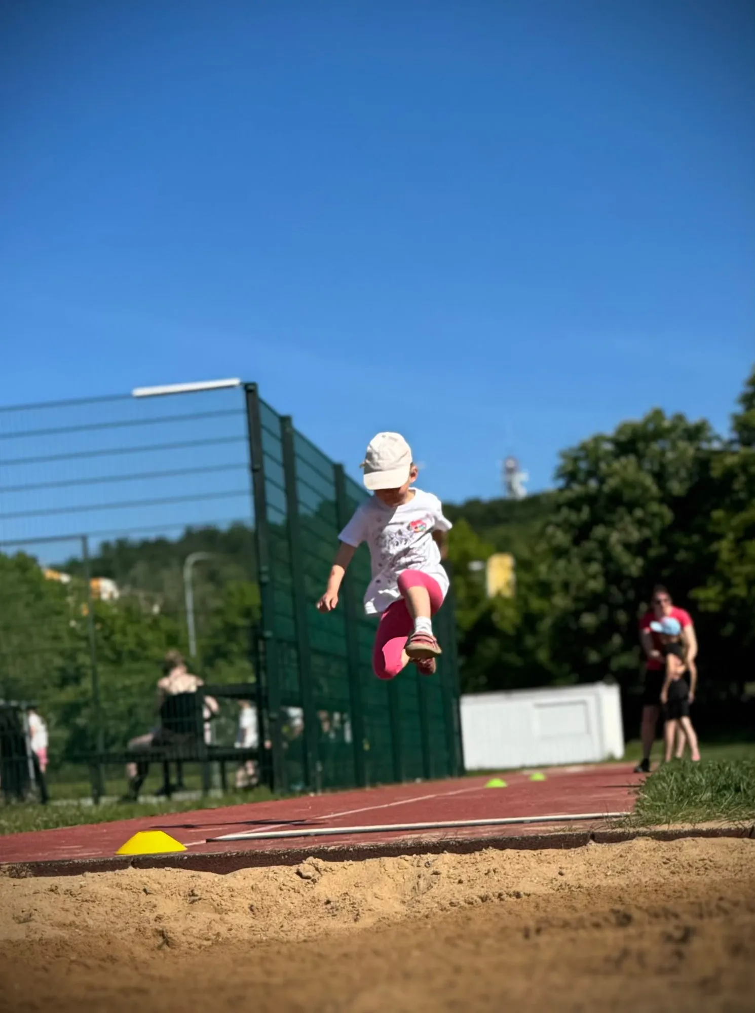 Dítě při skoku na atletickém tréninku v areálu ZŠ Burešova, Praha 8